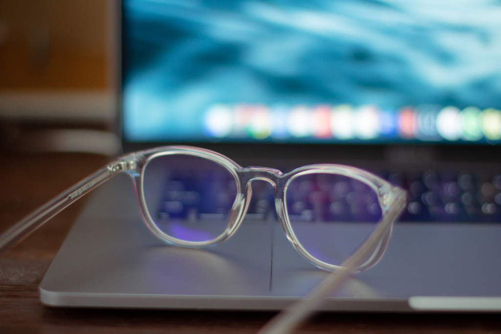 un par de anteojos de plástico transparente con revestimiento de luz azul sentado en una computadora portátil abierta